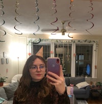a woman taking a selfie in front of a room full of streamers